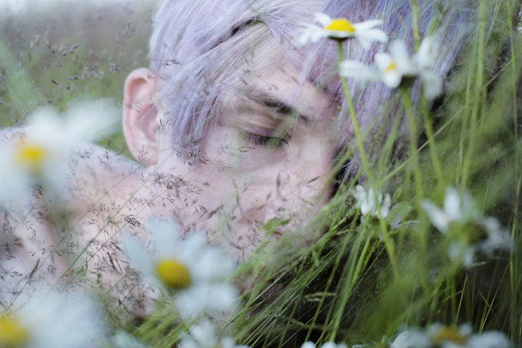 Close-up of teenage boy sleeping by flowers