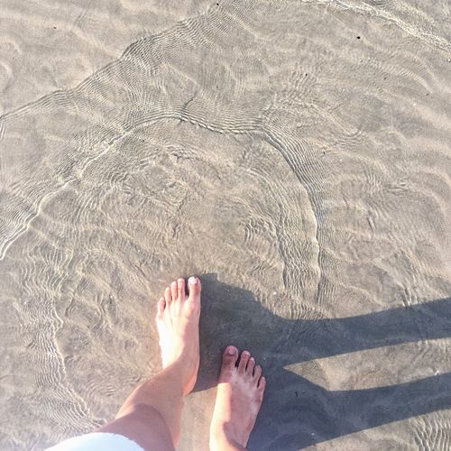 Low section of man wading in sea