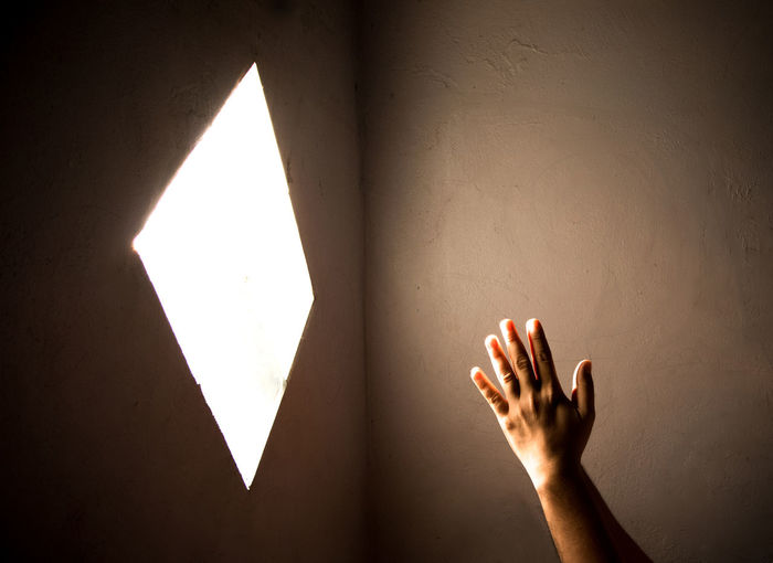 Close-up of praying hand holding illuminated light