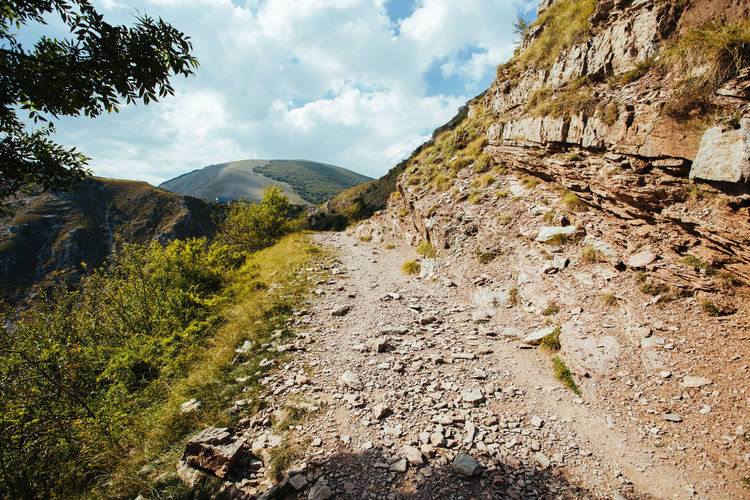 Gravel mountain road in the mountain ideal for hiking in the fresh air enviroment.