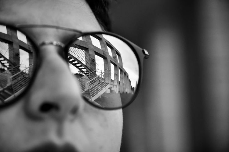 Reflection of built structure on sunglasses wore by woman