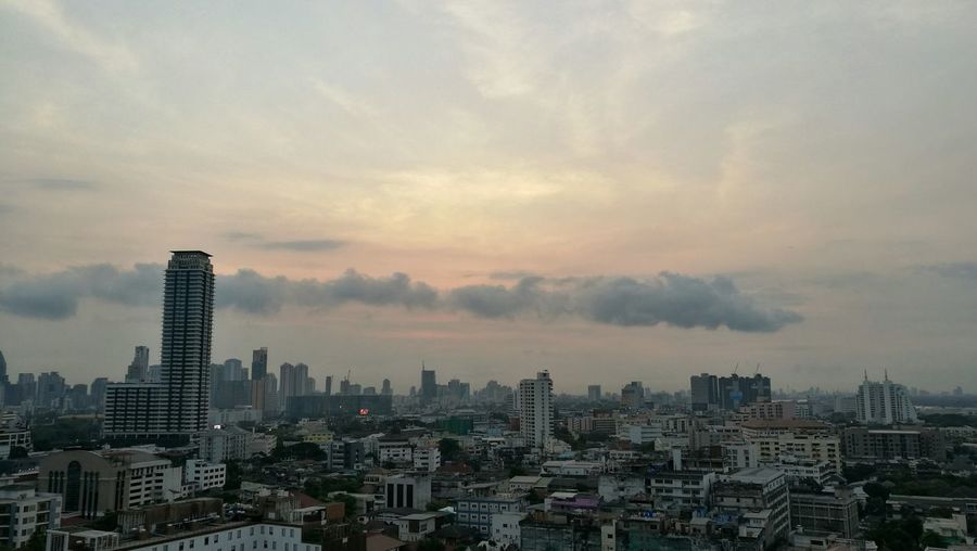 View of cityscape against cloudy sky