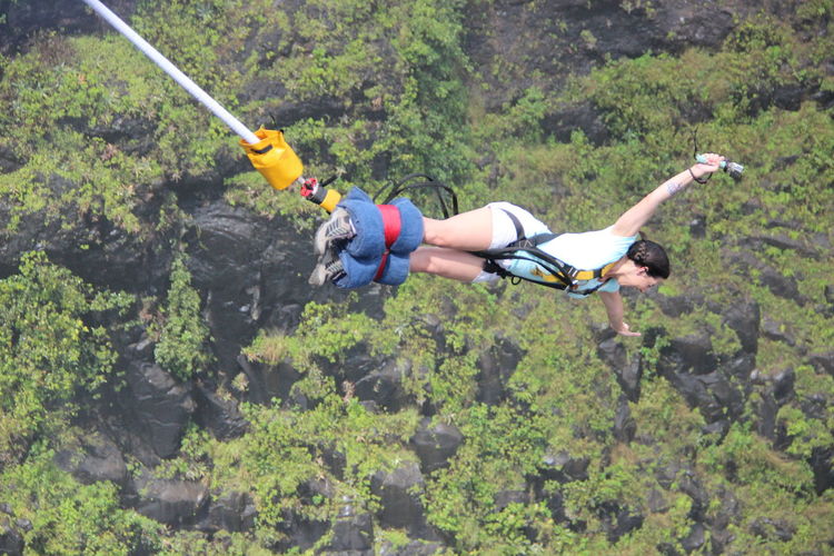 High angle view of young woman bungee jumping