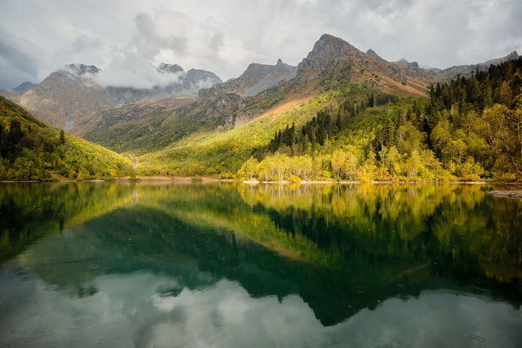 Beautiful autumn landscape, mountain lake, coniferous forest, mirror reflection. russia, kardyvach