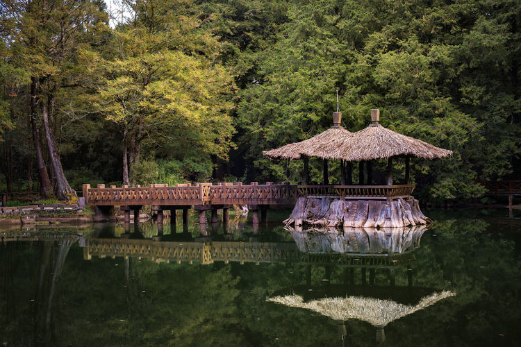 Built structure by lake against trees