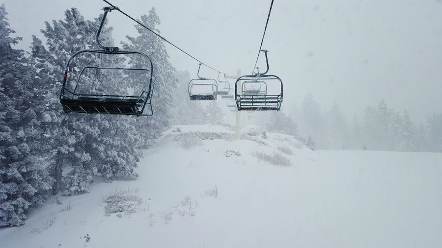 Empty ski lifts over snow covered field