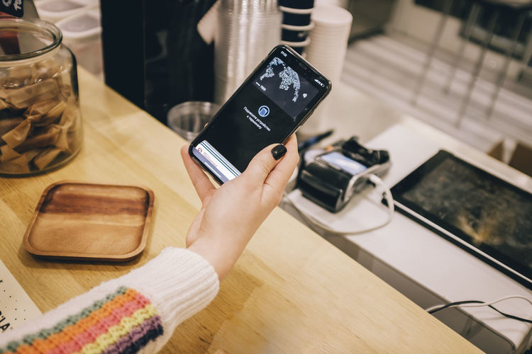 Midsection of man using mobile phone on table