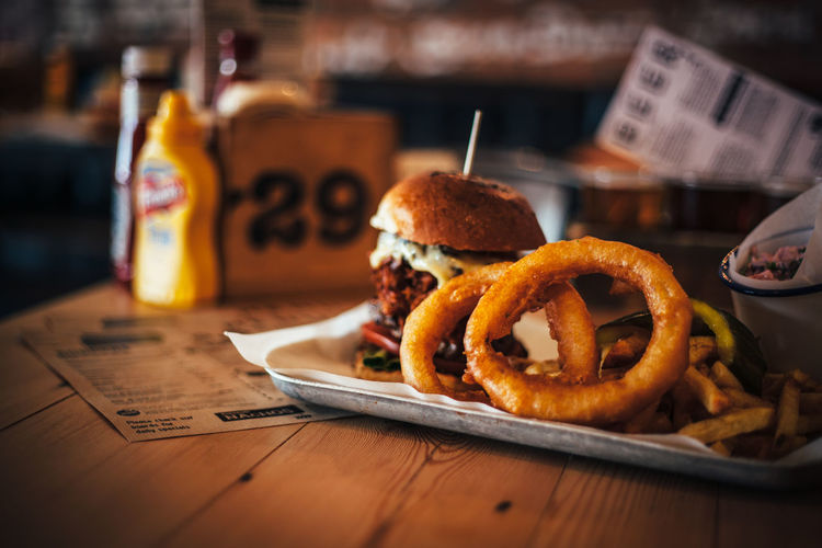 Close-up of burger and onion rings on table