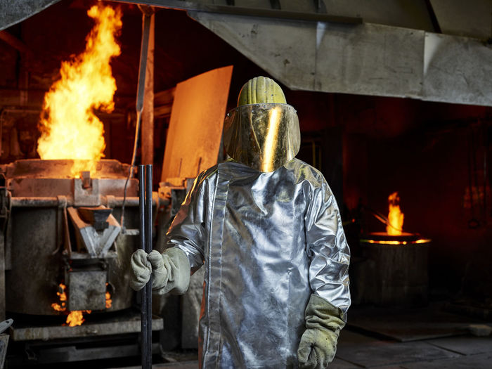 Rear view of man welding in factory