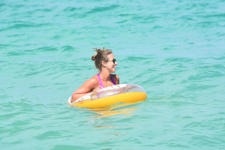 Young woman with inflatable ring in sea