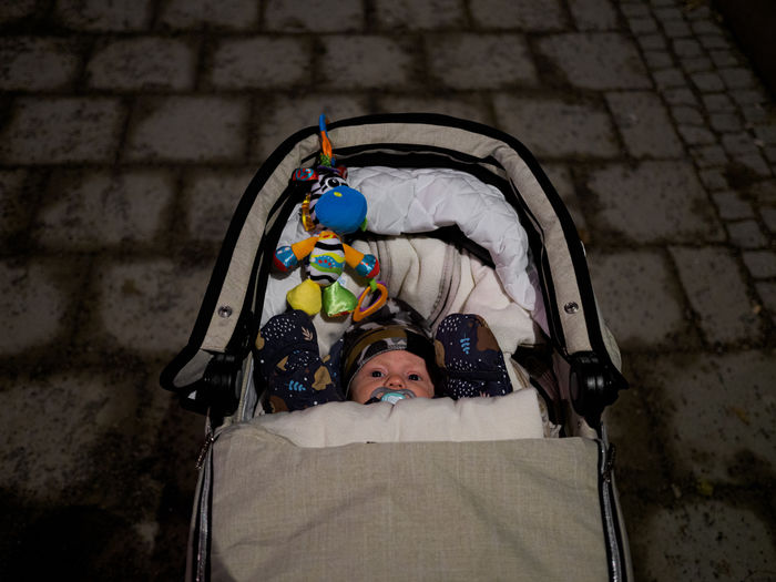Overhead view of an infant dressed in warm clothing in a stroller at night