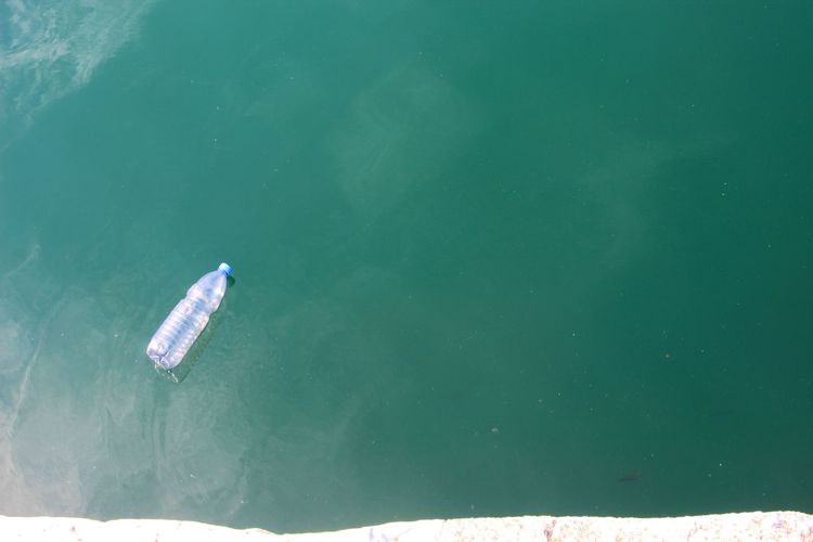 High angle view of bottle floating on sea
