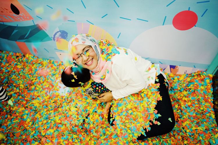 High angle view of mother and son with confetti in room