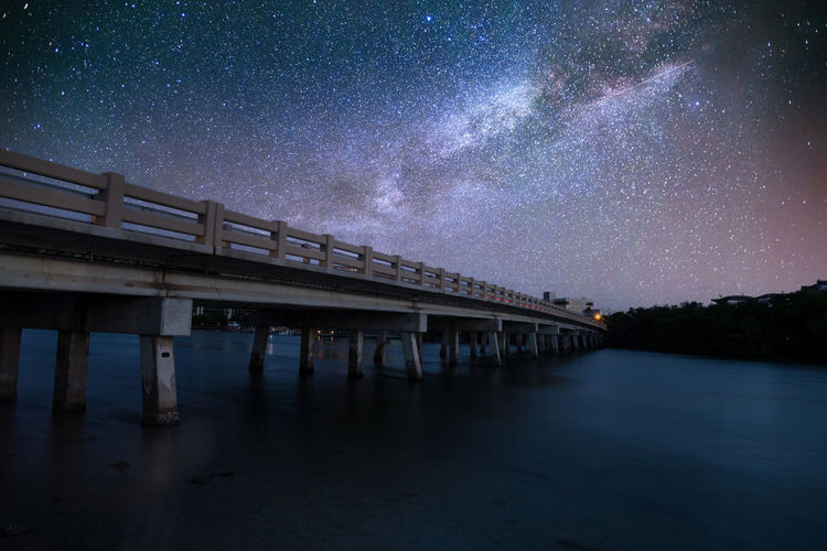 Night sky over the bridge over hickory pass leading to the ocean in bonita springs, florida.