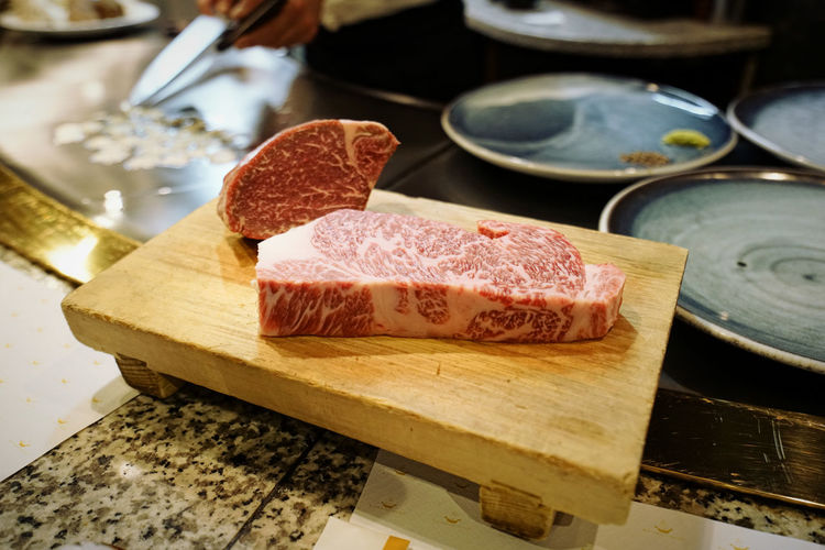 Close-up of red meat on cutting board over table