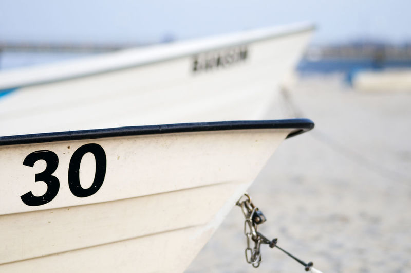 Small white fishing boat with the number 30 on the beach for the usedom peninsula in the summer.