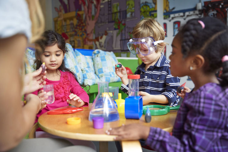 Children doing science experiment at table in preschool