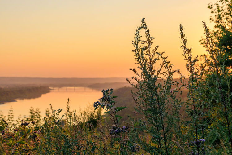 Scenic view of distant river against sky during sunset