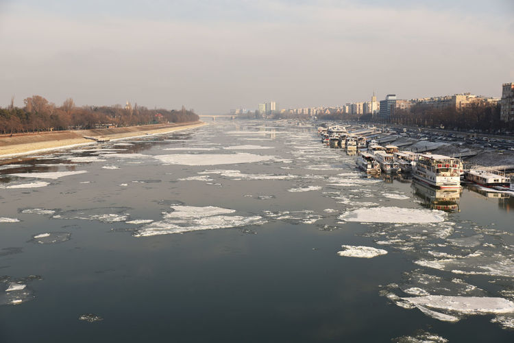 Aerial view of cityscape by sea against sky