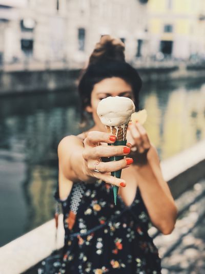 Midsection of woman holding ice cream outdoors