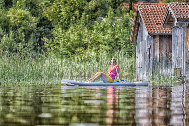 Woman relaxing on paddleboard in lake