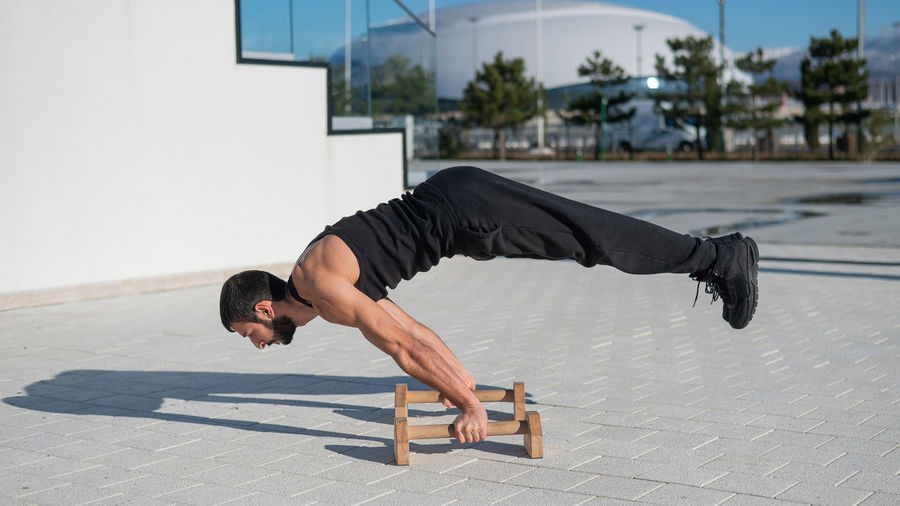 Man doing balance exercise on floor bars for fitness. 