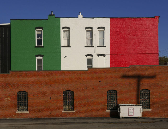 Italian flag paint on building against clear sky