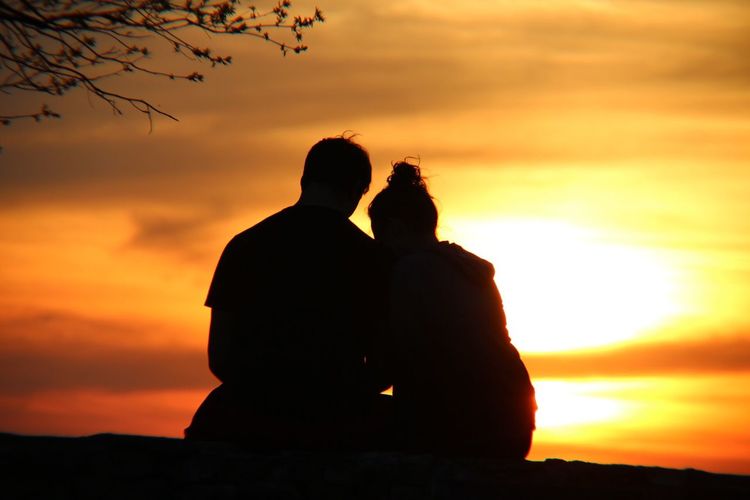 Silhouette couple against sky during sunset