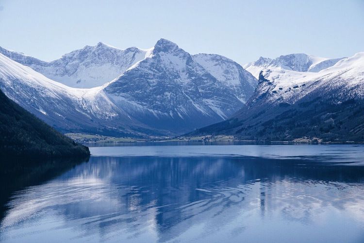 Scenic view of lake and snowcapped mountains against clear sky