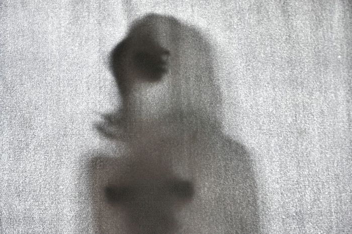Shadow of woman on curtain at home