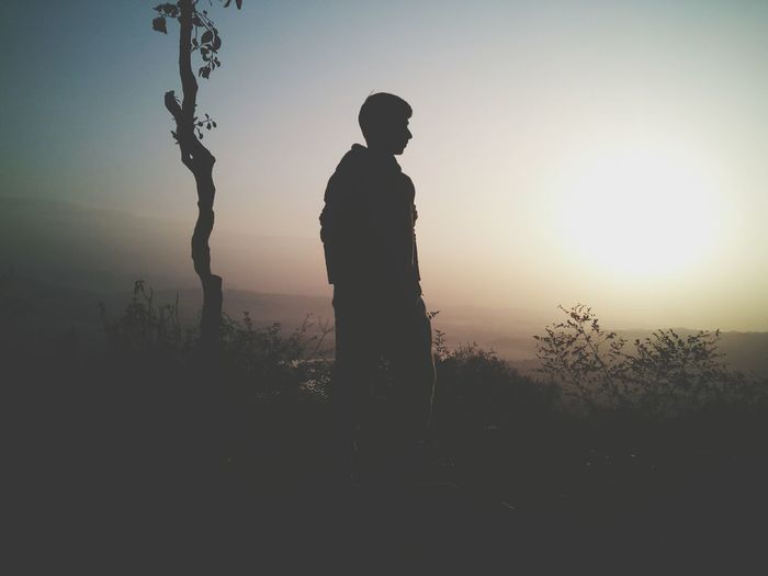 Silhouette of young man looking at view