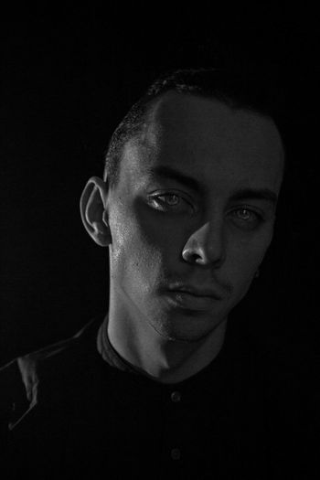 Close-up portrait of young man against black background