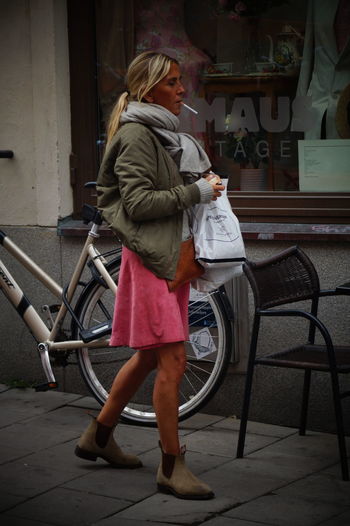 Side view of woman holding bicycle