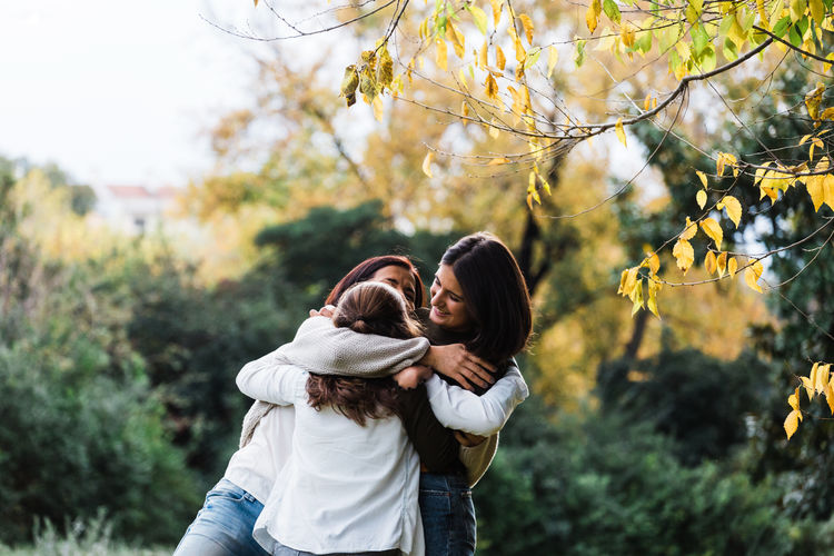 Daughters Mother Adult Beauty In Nature Bonding Casual Clothing Cheerful Day Embracing Friendship Happiness Leisure Activity Lifestyles Love Nature Outdoors People Real People Smiling Standing Togetherness Tree Women Young Adult Young Women Fresh On Market 2018