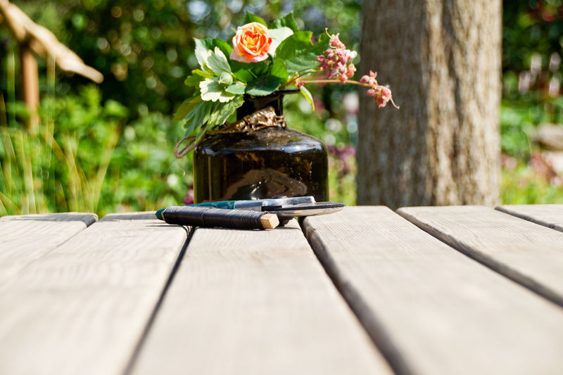 Surface level of flower vase with string and pruning shears on wooden table