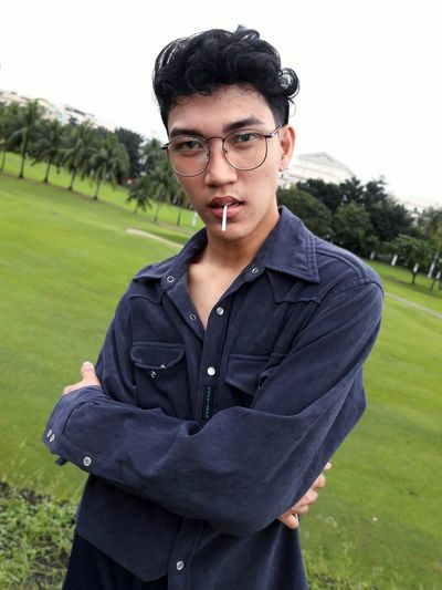 Portrait of young man wearing eyeglasses on field