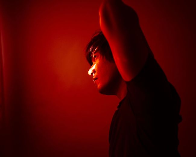 Portrait of young man against red background