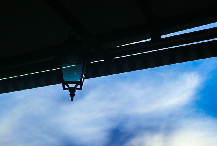 Low angle view of illuminated light against blue sky