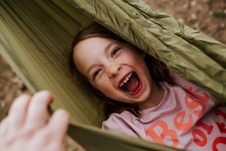Overhead of silly girl laughing in hammock
