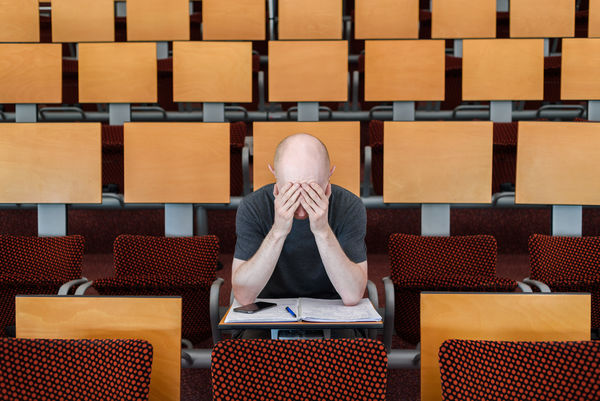 Frustrated man sitting in examination hall