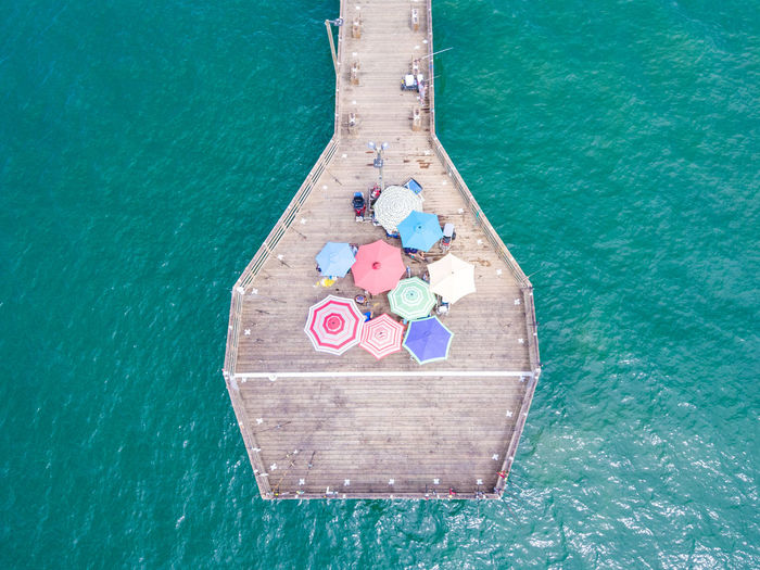 Pier with umbrellas above the ocean