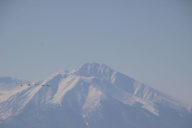 Aerial view of snow covered mountain against sky