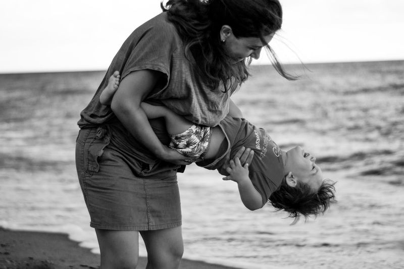 Woman playing with child on beach