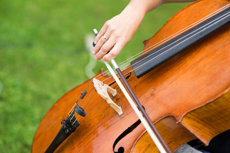 Cropped hand of woman playing violin at park