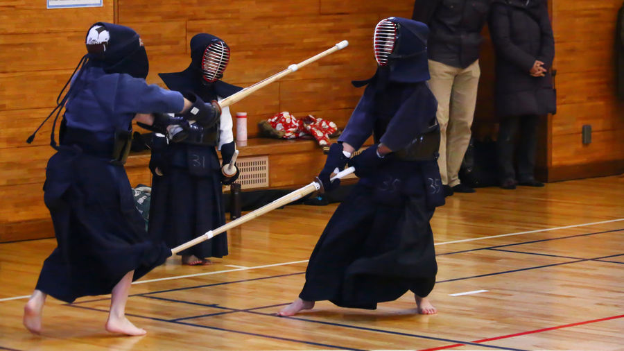 Three people practicing kendo