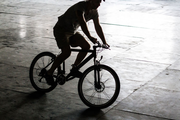 High angle view of man cycling on tiled floor