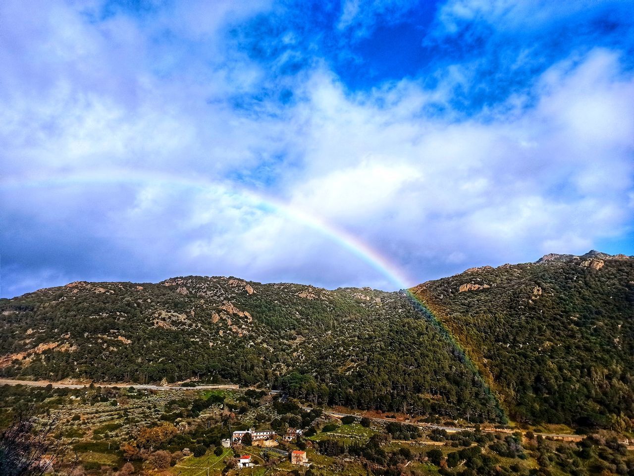 SCENIC VIEW OF RAINBOW OVER MOUNTAIN AGAINST SKY