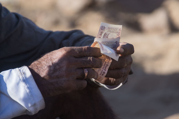 Close-up of man holding paper currency