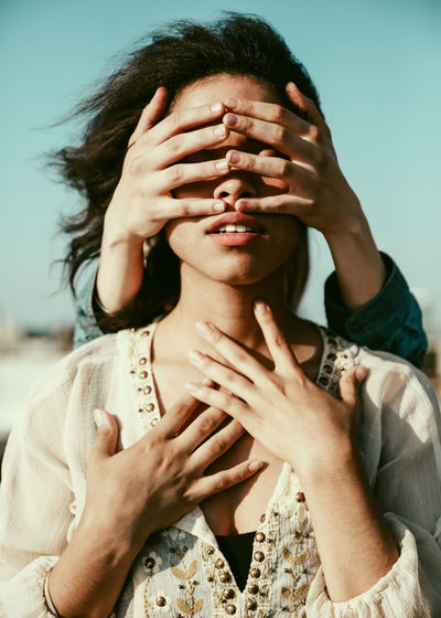 Portrait of person covering face with hands