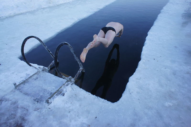 Full length of man diving in frozen swimming pool